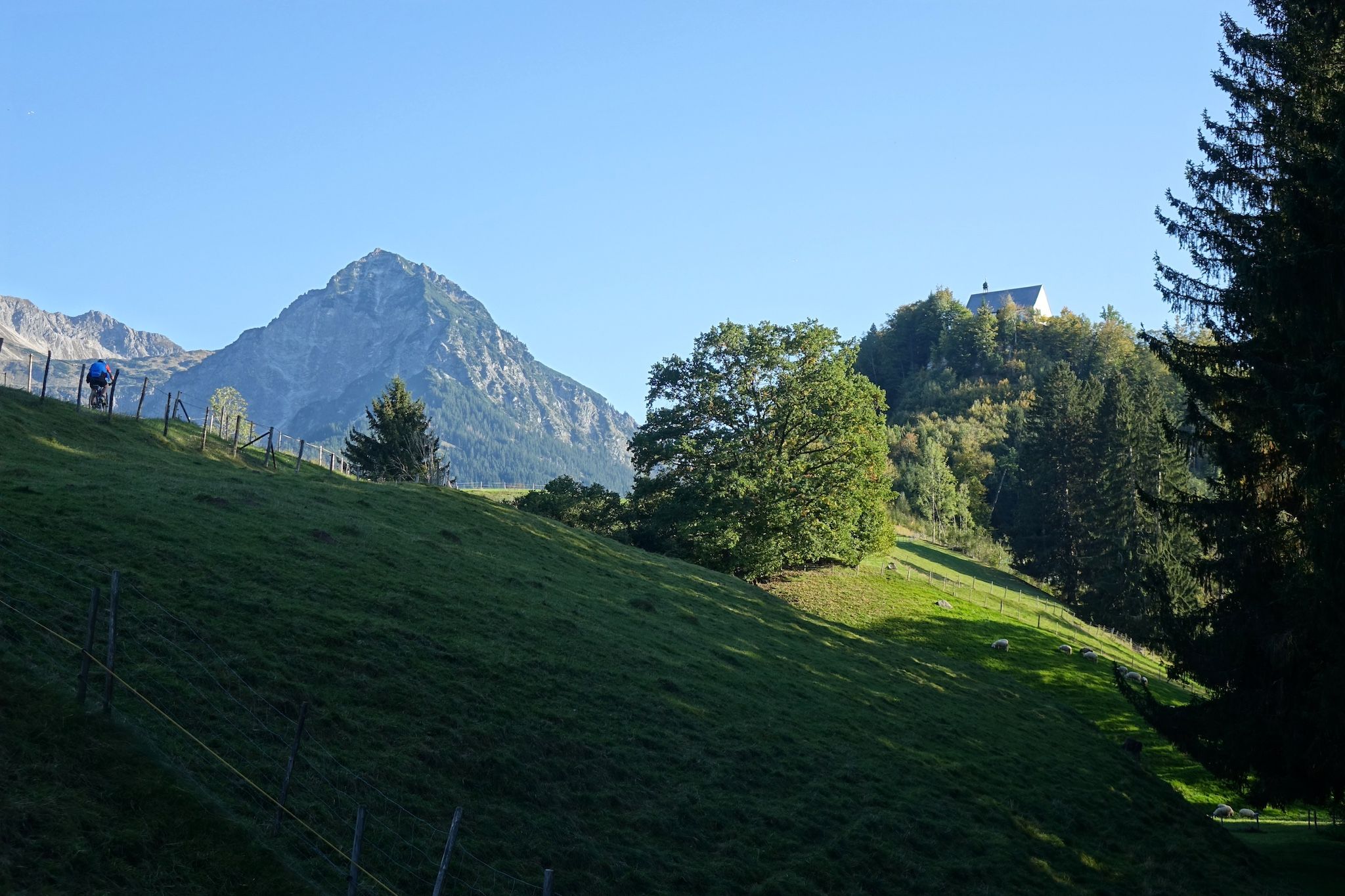 Die Schöllanger Burgkirche und das Rubihorn thronen über Fischen im Allgäu