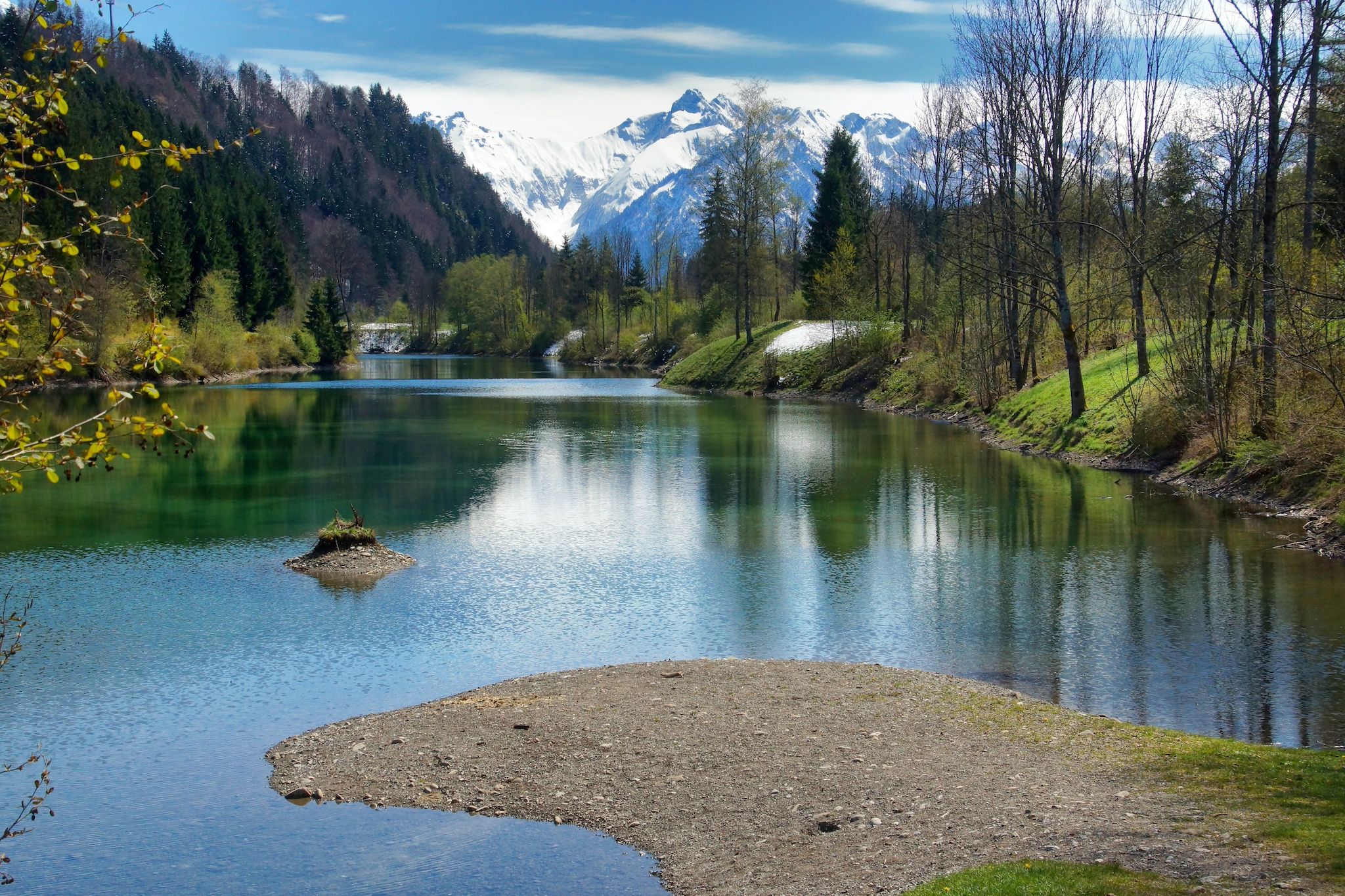 Frühlingsstimmung mit verschneiten Bergen am Auwaldsee in Fischen in den Allgäuer Hörnerdörfern