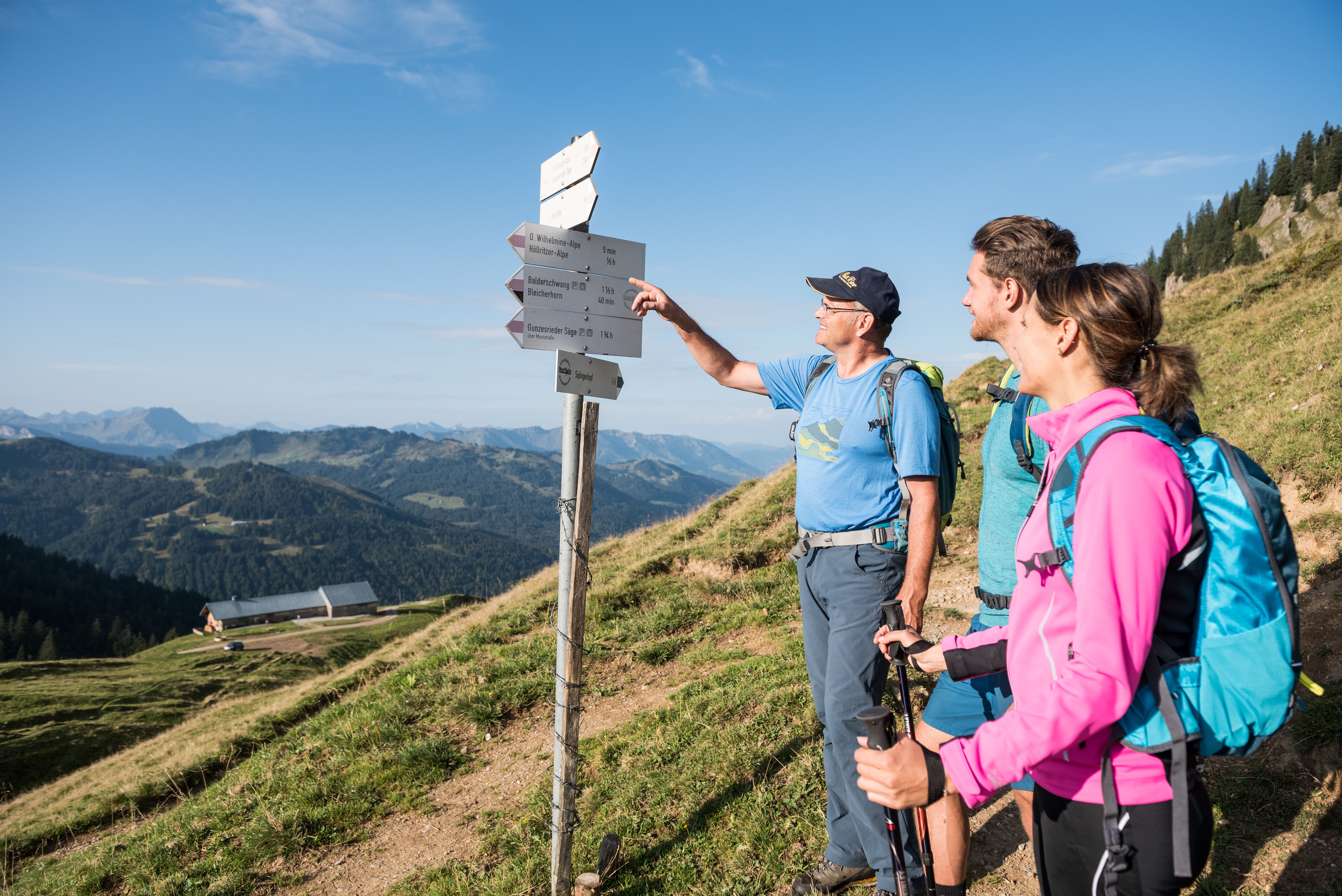 Wandern mit Bergführer am Wegweiser in Balderschwang - Hörnerdörfer im Allgäu