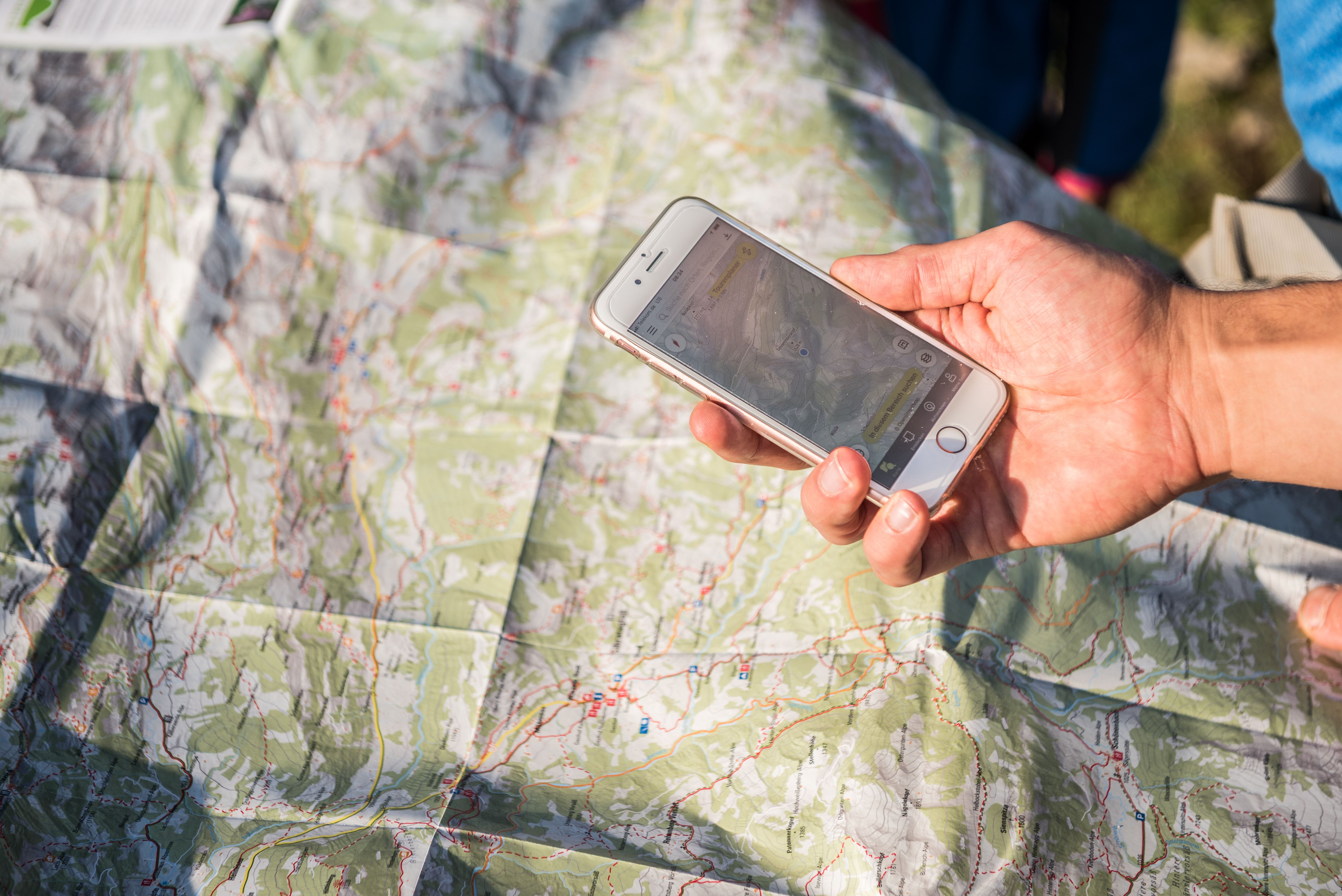 Wanderkarte und Smartphone zur Orientierung beim Wandern